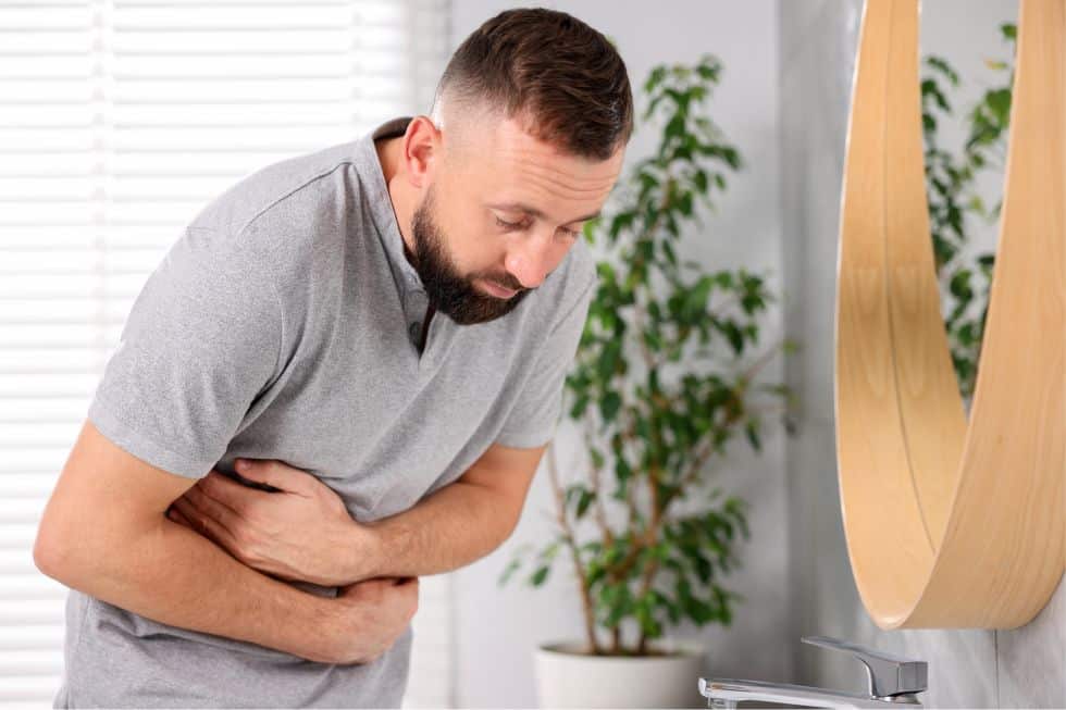 A man keels over in chronic pain and discomfort.